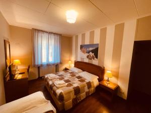 a hotel room with two beds and two lamps at Antica Locanda La Posta in Gaggio Montano