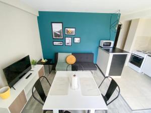 sala de estar con mesa blanca y pared azul en Amanecer del Fuego IV en Ushuaia