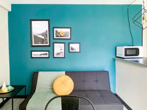 - un salon avec un canapé et un mur bleu dans l'établissement Amanecer del Fuego IV, à Ushuaia