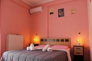1 dormitorio con 2 camas y paredes de color rosa en Guesthouse Alexandros, en Pýli