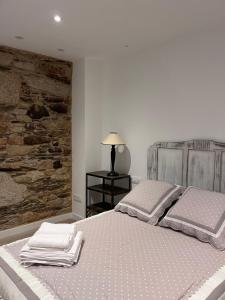 1 dormitorio con 1 cama con 2 toallas en Caraxolas, en Lugo