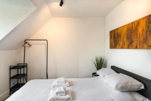KentにあるSeascape loft - Ramsgate Modern three bedroom apartmentのベッドルーム1室(白いシーツとタオル付きのベッド1台付)