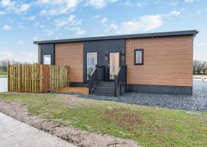 uma casa com um exterior de madeira e preto em Hambleton Lakeside Lodges em Poulton le Fylde