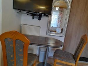 a dining room table with a mirror and a chair at Classic Appartments in Knittelfeld