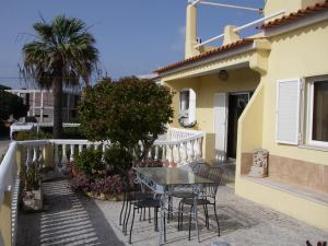 una mesa y sillas en el balcón de una casa en Monte da Ria Guest House, en Faro