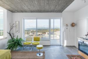 KabriSea view的厨房配有黄色的椅子和一张桌子,享有美景。