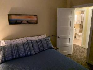 Un dormitorio con una cama azul con una pintura en la pared en Cottage11 of Avalon: 2 Bedroom, Laundry, RV parking. Quiet, en Lansing