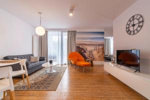 salon z kanapą i telewizorem w obiekcie Apartament DREAM w Pogorzelicy