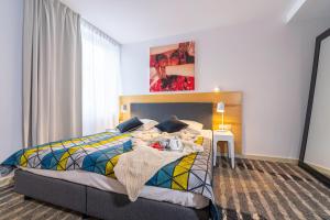 sypialnia z łóżkiem z kolorowym kocem w obiekcie Apartament DREAM w Pogorzelicy
