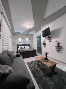 a living room with a couch and a table at LV Spa & Apartment in Ledinci