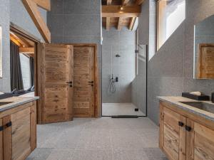 a bathroom with a shower and a wooden door at Chalet neuf avec piscine, sauna et proche des pistes à Courchevel Village - FR-1-562-49 in Courchevel +6 photos