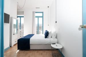 um quarto branco com uma cama e uma mesa em Des Arts em Amarante