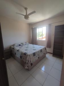 1 dormitorio con cama y ventana en Seu Apê na Enseada Azul - Bacutia !!!, en Guarapari