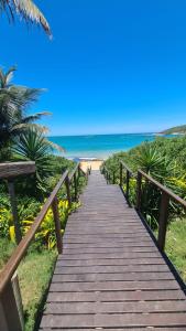 a wooden boardwalk leading to the beach at Seu Apê na Enseada Azul - Bacutia !!! in Guarapari