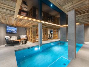 a swimming pool in a house with a living room at Chalet Courchevel 1550, 7 pièces, 14 personnes - FR-1-562-47 in Courchevel