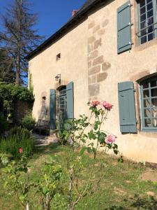 una casa con persiane verdi e fiori nel cortile di Château de Montautre a Fromental