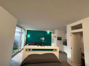Cette chambre est dotée d'un mur vert et d'une cuisine avec un évier. dans l'établissement Green space studio in the center, à Rome