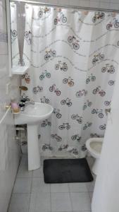 uma casa de banho com uma cortina de chuveiro, um WC e um lavatório. em Beagle House Centro em Ushuaia