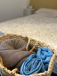 una cesta llena de toallas sentadas en una cama en Suíte Pontal, en Arraial do Cabo