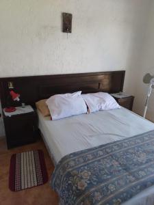 1 cama con cabecero de madera en un dormitorio en Casa en Sierras del Mar en Cuchilla Alta