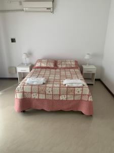 1 dormitorio con 1 cama con manta y 2 mesas en Mein Gästehaus en Gualeguaychú