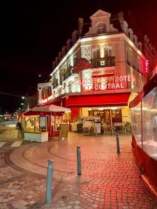 un gran edificio con un restaurante enfrente en Les mouettes de Trouville en Trouville-sur-Mer
