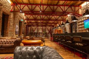 a large room with couches and tables and chairs at Melesin Distillery in Leskovik