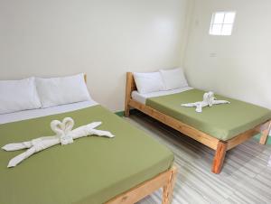 a room with two beds with towels on them at Charlina Inn Panglao in Panglao Island