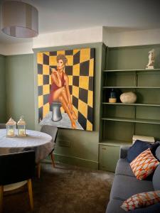 a living room with a painting of a woman on the wall at Historic & Stylish Cottage in Charlton Kings