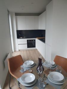 een keuken met een tafel met borden en wijnglazen bij Lovely 2Bedroom Apartment in Manchester