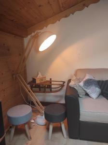 - un salon avec une lampe, un canapé et un tabouret dans l'établissement Le chalet de Bernoline vaste appartement tout confort, à Beaufort