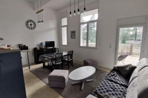 een woonkamer met een bank en een tafel bij Appartement T3 * * * + Piscine in La Tranche-sur-Mer