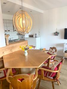 a dining room with a wooden table and chairs at FeWo Alpenwiese mit Hallenbad&Sauna in Missen-Wilhams