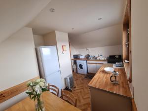 a small kitchen with a table and a refrigerator at Almondbank Self Catering Apartment in Skeabost