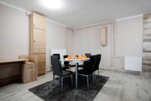 a dining room with a table and black chairs at Noel Vendégház in Szeged
