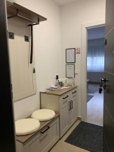 a kitchen with a sink and a counter with two stools at FIOLICA in Zaprešić