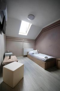 1 dormitorio con 1 cama y tragaluz en Noel Vendégház, en Szeged