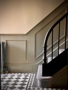 a staircase in a room with a checkered floor at Historic & Stylish Cottage in Charlton Kings