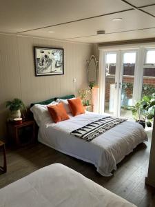 ein Schlafzimmer mit einem großen Bett mit orangefarbenen Kissen in der Unterkunft Cabin Retreat in the heart of Warwick. in Warwick
