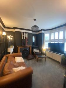 a living room with a couch and a fireplace at Historic & Stylish Cottage in Charlton Kings