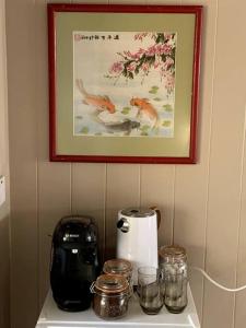 a counter with a toaster and a picture on the wall at Cabin Retreat in the heart of Warwick. in Warwick