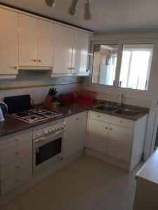 cocina con armarios blancos y fogones en Apartment Kristal Mar, en Moraira