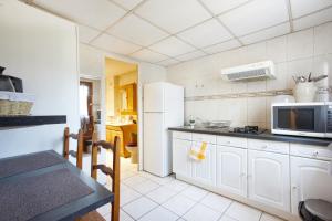 a kitchen with a white refrigerator and a microwave at Agréable maison en centre ville in Noisy-le-Grand