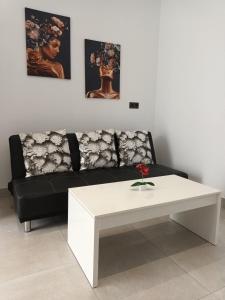 ein Wohnzimmer mit einem schwarzen Sofa und einem weißen Couchtisch in der Unterkunft La Gaviota in Arrecife