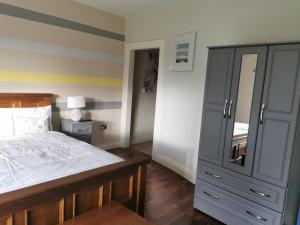 ein Schlafzimmer mit einem großen Bett und einer Kommode in der Unterkunft Ard Aoibhinn Roscommon in Lecarrow