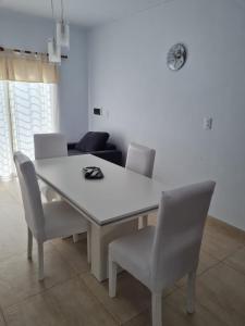 a white dining room table with chairs and a couch at Del Sur Alquiler temporario in Sunchales