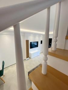 a living room with white columns and a television at Sunrise Luxury House in Pefkochori