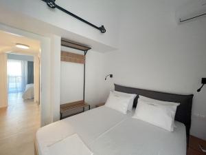 a bedroom with a white bed with white pillows at Sunrise Luxury House in Pefkochori