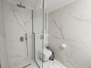 a white bathroom with a shower and a toilet at Sunrise Luxury House in Pefkochori +48 photos