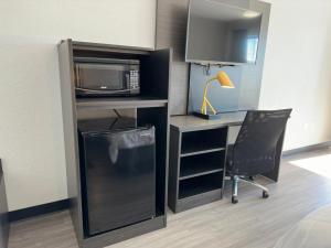 a room with a desk with a microwave and a desk with a chair at Baymont by Wyndham Rock Hill in Rock Hill